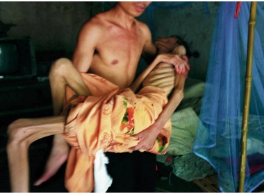 在河南艾滋病村，一村民抱着一副亲人的骨架