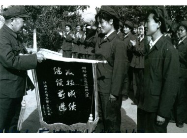 1982年，女兵八连为军区团以上干部会议作汇报表演，军区首长给连队授旗，李萍连长代表全连接旗