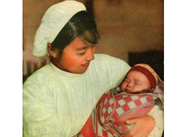 张秋人民公社产院里的助产士魏家珍，抱着亲手接生的婴儿快慰地笑