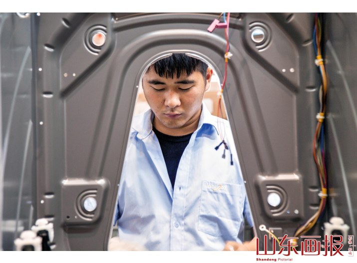 惠而浦洗衣机制造车间的技术工人和质检人员