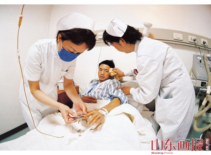 护理人员为受伤同胞做生活护理