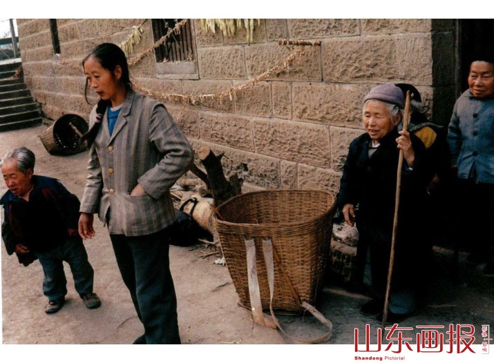 敬老院里的几位老人与前来买菜的邻村姑娘在一起