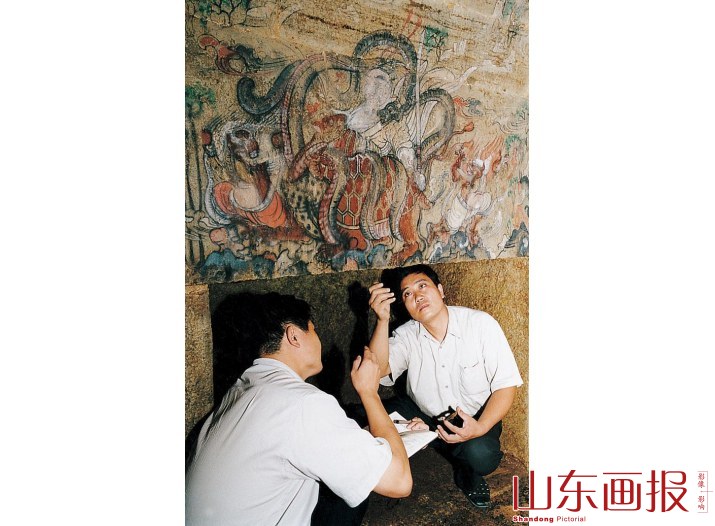 宫德杰与考古人员对北齐古墓壁画进行清理登记