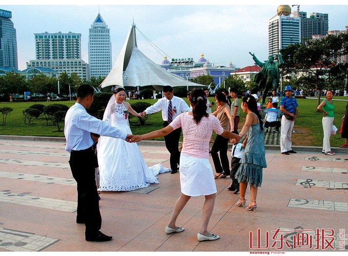 新婚夫妇与亲朋好友在音乐广场共舞