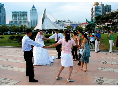 新婚夫妇与亲朋好友在音乐广场共舞