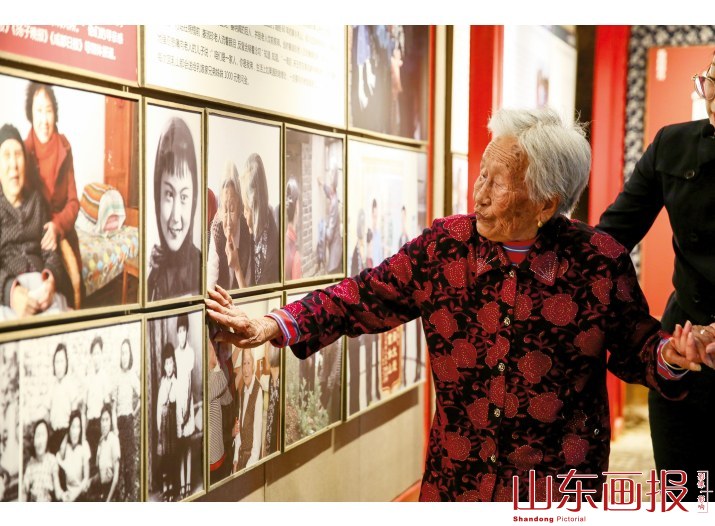 王葵敏抚摸着墙上的照片