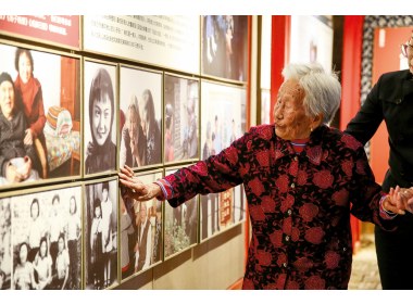 王葵敏抚摸着墙上的照片