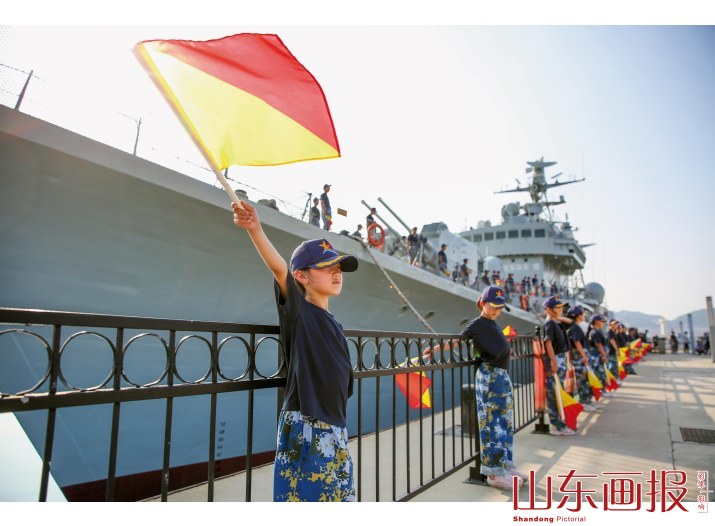 孩子们用旗语向110舰致敬