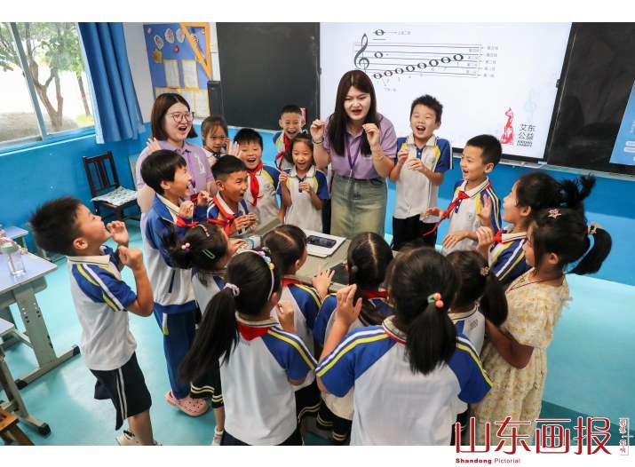 音乐课上志愿者教学生们认识五线谱